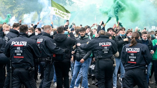 Mehrere Polizisten drängen einige Werder-Fans zurück.