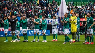 Die Werder-Mannschaft steht nach dem Unentschieden gegen St. Pauli vor der Fankurve und applaudiert.