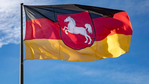 Die Flagge des Landes Niedersachsen weht im Wind.