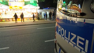 Ein Polizeiwagen steht vor einer Bude auf dem Bremer Freimarkt. 