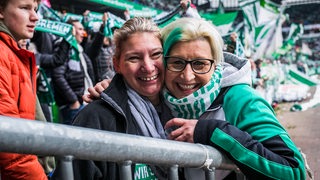 Zwei weibliche Werder-Fans lächeln im Weser-Stadion in die Kamera.