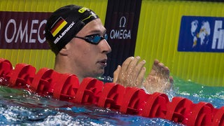 Schwimmer Florian Wellbrock schaut nach einem Rennen im Becken zur Anzeigetafel.
