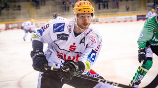 Pinguins-Stürmer Jan Urbas hält seinen Eishockey-Schläger hoch und fährt zur Bande. 