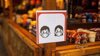 Ein Hinweisschild zur Maskenpflicht an einem Verkaufsstand 