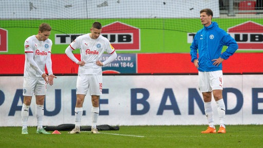 Spieler von Holstein Kiel sind nach dem Abpfiff enttäuscht. 