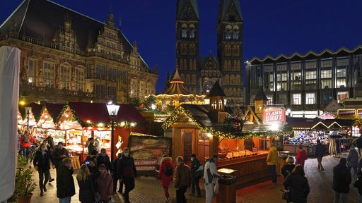 Buden auf dem Bremer Weihnachtsmarkt erhellen den Marktplatz.