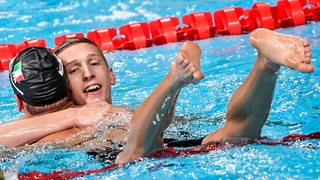 Schwimmer Florian Wellbrock liegt nach seinem Weltrekord über 1.500 Meter Freistil bei der Kurzbahn-Weltmeisterschaft im Wasser seinem Konkurrenten Gregorio Paltrinieri in den Armen.