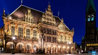 Das Rathaus und der Bremer Dom sind in den Abenstunden hell erleuchtet.