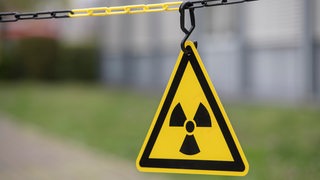 Ein Atomkraft-Zeichen hängt an einem Absperrband.