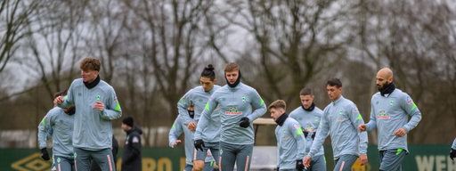 Werder-Spieler Woltemade, Füllkrug und Toprak springen über Hürden im Training.