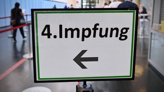 Auf einem Schild steht "Vierte Impfung".