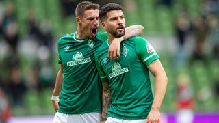 Die Werder-Verteidiger Marco Friedl und Anthony Jung bejubeln einen Treffer.