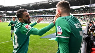 Werder-Spieler Leonardo Bittencourt gibt seinem Teamkollegen Marvin Duckschb beim Torjubel eine Backpfeife.