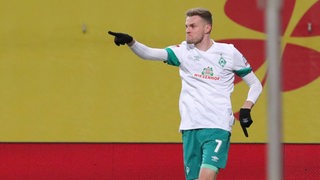 Werder-Stürmer Marvin Ducksch zeigt nach seinem Tor in Rostock mit ausgestrecktem Finger auf seine Teamkollegen.