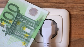 Ein hundert Euro Schein neben einer Steckdose