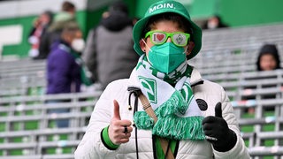Ein Werder-Fraun mit Anglerhut und Werder-Sonnebrille hebt zufrieden die Daumen.
