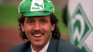 Jonny Otten lächelt und trägt eine Werder-Mütze.
