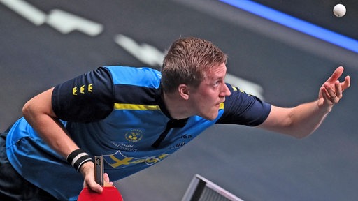 Tischtennis-Profi Mattias Falck fixiert beim Aufschlag den in die Luft geworfenen Ball.