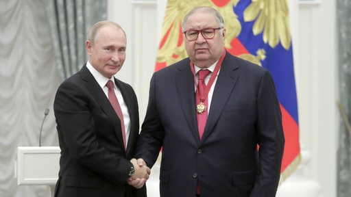 Der russische Oligrach Alisher Usmanow steht neben Präsident Putin.