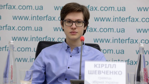 Kirill Shevchenko sitzt bei einer Pressekonferenz auf dem Podium.