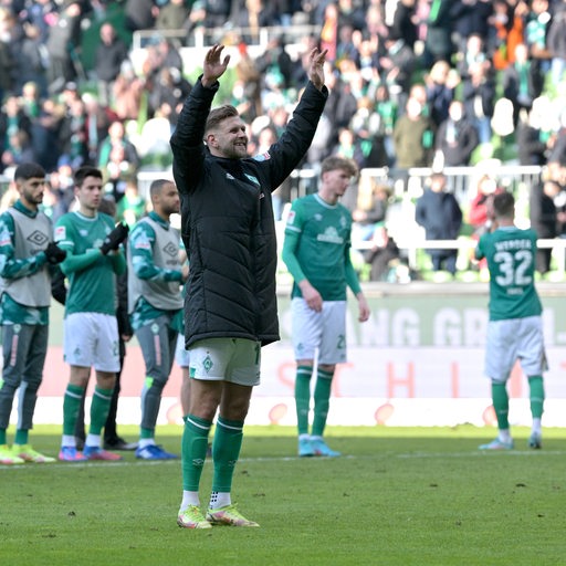 Die Werder-Spieler applaudieren den Werder-Fans in der Ostkurve, während Niclas Füllkrug mit hochgereckten Armen vor ihnen steht und gefeiert wird.