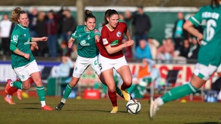 Werder-Spielerin Riecke Dieckmann zieht einer Gegenspielerin am Trikot.