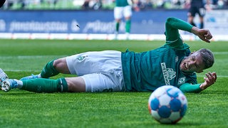 Werder-Spieler Mitchell Weiser liegt verletzt am Boden.