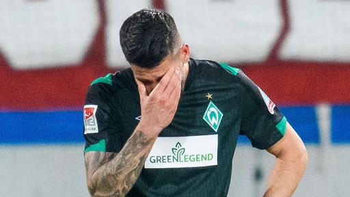 Werder-Spieler Anthony Jung fasst sich mit hängendem Kopf vors Gesicht nach dem Gegentor.
