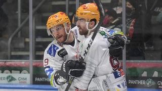 Pinguins-Spieler Jan Urbas und Miha Verlic bejubeln auf dem Eis einen Treffer.