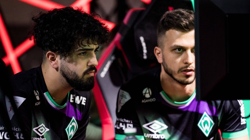 Die Werder E-Sportler Ali Predatorfifa Oskoui Rad und Fabio FIFABIO97 Sabbagh schauen konzentriert auf den Bildschirm.