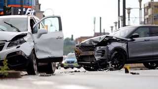 Zwei SUV sind nach einem Unfall auf der Aachener Straße schwer beschädigt. Die Polizei sperrt die Fahrbahn und sichert die Unfallstelle. 