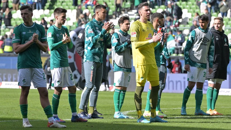 Werder-Spieler stehen nach dem Spiel aufgereiht vor der Ostkurve und applaudieren den Fans.