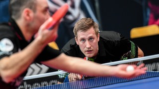 Werders Tischtennis-Spieler Mattias Falck konzentriert und tief an die Platte heruntergebeugt, in Erwartung des Aufschlags von Gegner Ioannis Sgouropoulos.
