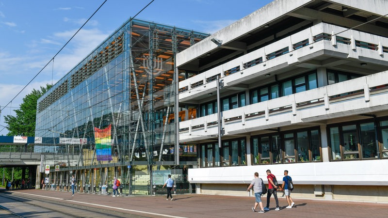 Mehrere Studenten schlendern an der Glashalle vor der Bremer Universität entlang.