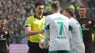 Werder-Spieler diskutieren mit Schiedsrichter Florian Badstübner.