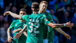 Die Werder-Spieler Marco Frield und Mitchell Weiser bejubeln einen Treffer.