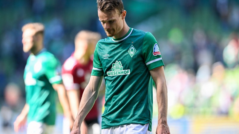 Werder-Spieler Christian Groß steht mit gesenktem Kopf auf dem Spielfeld.