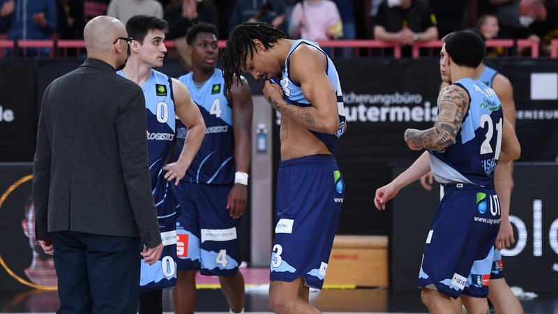 Enttäuschte Basketballer der Eisbären Bremerhaven stehen um Trainer Allen Ray Smith herum.