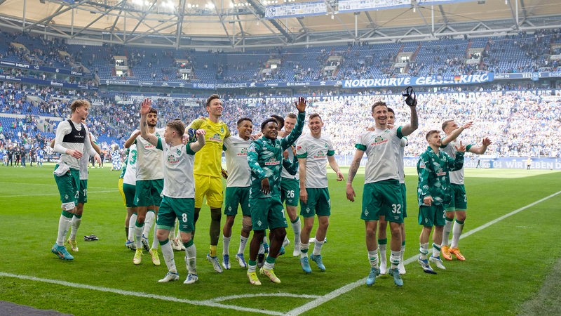 Das Werder-Team jubelt im Schalker Stadion vor den Fans.
