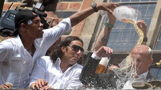 Claudio Pizarro und Naldo verpassen bei der Pokalfeier auf dem Bremer Rathaus-Balkon Trainer Thomas Schaaf mit einer Bierdusche.