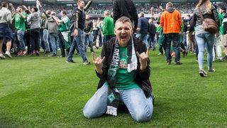 Werder-Fans haben nach dem Klassenerhalt den Rasen des Weser-Stadions jubelnd erstürmt.