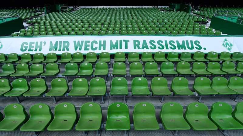Blick auf ein Banner auf den leeren Sitzen der Tribüne im Weser-Stadion mit der Aufschrift: "Geh' mir wech mit Rassismus".