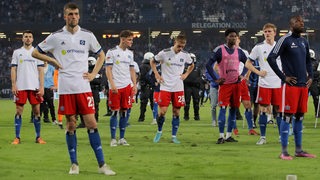 Merhere HSV-Spieler stehen nach Abpffif des Relegationsspiels mit traurigen Gesichtern auf dem Rasen.