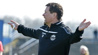 Torsten Gütschow steht als Trainer von Budissa Bautzen gestikulierend an der Seitenlinie.