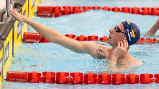 Schwimmstar Florian Wellbrock schaut nach einem Rennen über den Beckenrand.