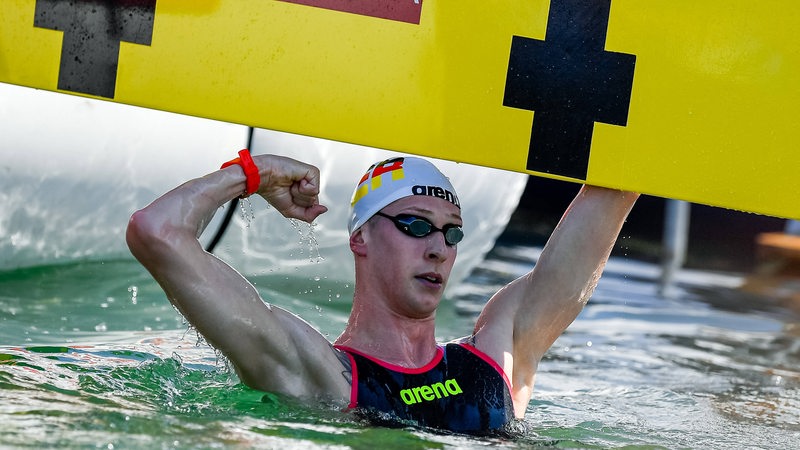 Florian Wellbrock schlägt im Ziel an und jubelt.