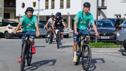 Werder-Spieler Romano Schmid und Niklas Schmidt auf Fahrrädern