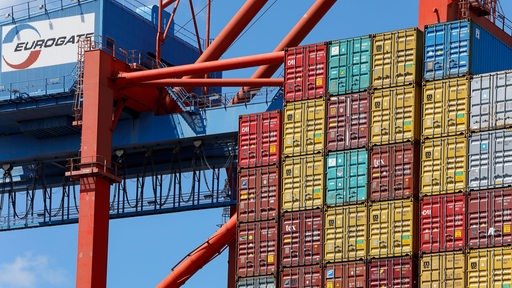 Eine Containerbrücke verfrachtet Container.