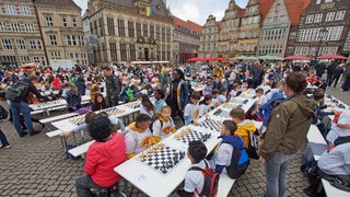 Etwa 1.000 Bremer Schulkinder spielen an Biertischen auf dem Marktplatz Schach.