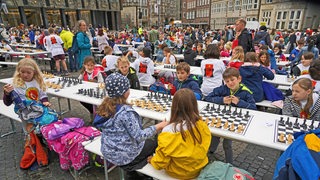 Etwa 1.000 Bremer Grundschülerinnen und Schüler spielen an Biertischen auf dem Marktplatz Schach.